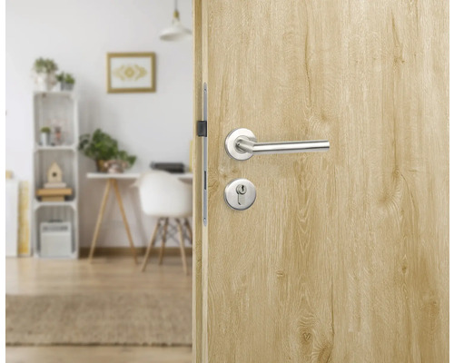Porte en bois avec poignée de porte et trou de serrure donnant sur une pièce lumineuse