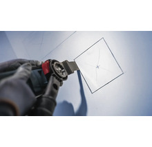 Outil multifonction oscillant coupant une ouverture carrée dans un mur.