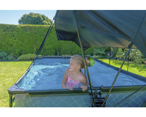 Fille dans une piscine hors sol rectangulaire avec protection solaire dans le jardin