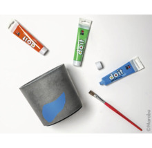 Pot de fleurs en béton avec peinture, pinceau et tubes de peinture