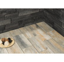 Wandverkleidung aus Stein und Bodenplatten im Aussenbereich.