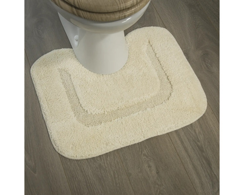 Tapis de bain de couleur claire devant des toilettes sur un plancher en bois