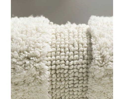 Nahaufnahme eines weißen Badteppichs mit unterschiedlichen Texturen