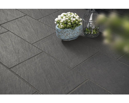 Dalles de terrasse foncées posées avec décoration.