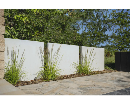 Gartenszene mit Sichtschutzelementen, Ziergräsern und Pflastersteinen