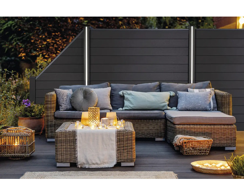 Terrasse mit Sichtschutzzaun und Rattansitzgruppe mit Kissen