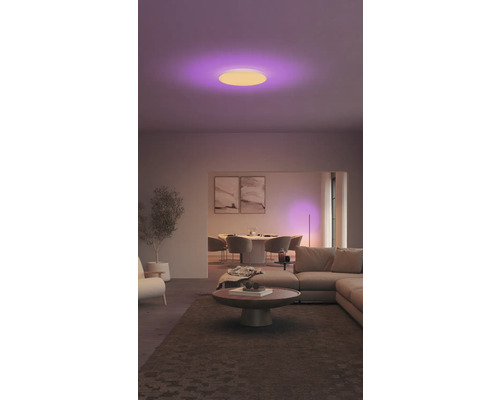 Wohnzimmer mit Esstisch, Sofa und runder Deckenleuchte mit Farbwechsel