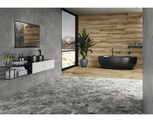 Badezimmer mit grauen und braunen Fliesen, Waschtisch, Spiegel und freistehender Badewanne.