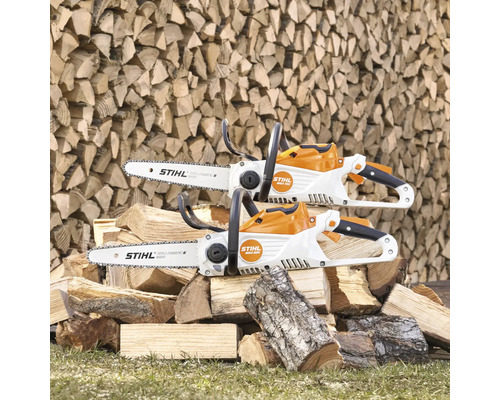 Deux tronçonneuses à batterie Stihl sur une pile de bois