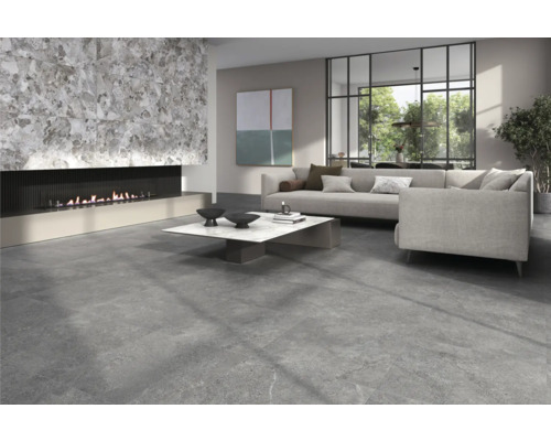 Wohnzimmer mit Steinfliesenboden, Kamin und grauer Couch