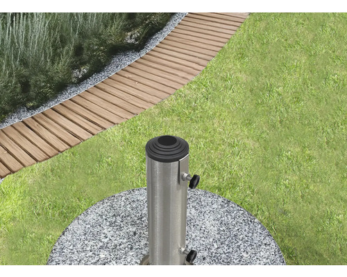 Gartenszene mit Rasen, Gehwegplatten und einem Sonnenschirmständer aus Granit und Metall.