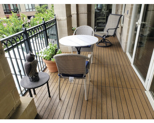 Scène de balcon avec lames de terrasse, table, chaises et décoration