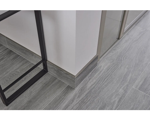 Gros plan d''un sol stratifié imitation bois gris avec des plinthes