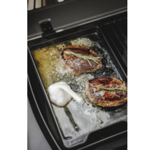 Deux steaks avec romarin et ail sur une plaque de grill