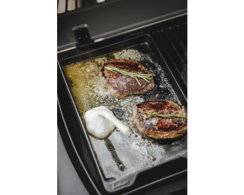 Deux steaks avec romarin et ail sur une plaque de grill