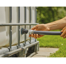 Person schliesst einen flexiblen Schlauch an einen IBC Container an