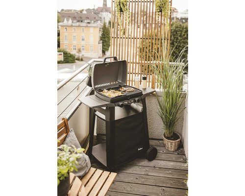 Barbecue à gaz sur un balcon avec des grillades et des plantes