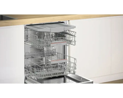 Lave-vaisselle ouvert avec paniers à vaisselle dans une cuisine lumineuse.