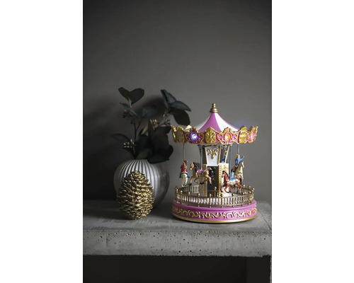 Dekoratives Karussell mit Beleuchtung, Vase und Tannenzapfen auf einem Tisch