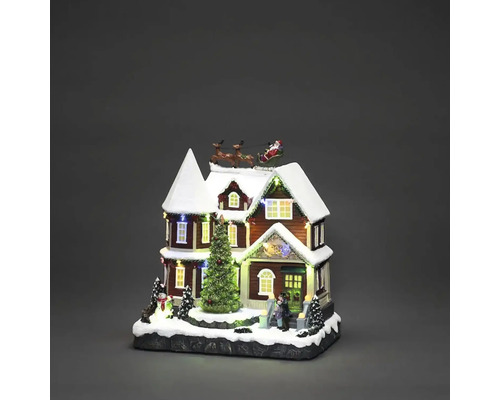 Beleuchtetes Weihnachtshaus mit Weihnachtsmann im Schlitten und Tannenbaum als Weihnachtsdekoration