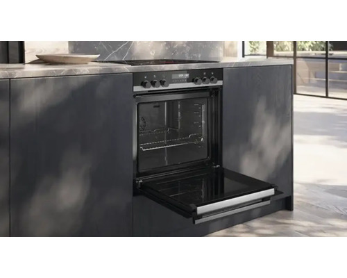 Four encastrable avec porte ouverte dans un îlot de cuisine.