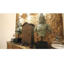Dekoratives Arrangement mit zwei Buddha-Statuen, einem Apothekerschrank und dekorativen Accessoires auf einem verzierten Sideboard.