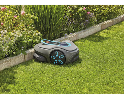Gardena Mähroboter auf Rasen neben Blumenbeet