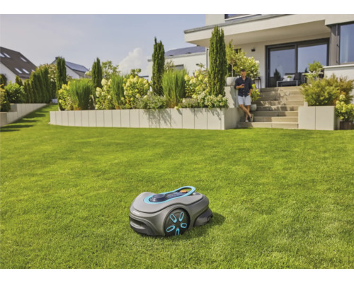 Robot tondeuse à gazon sur une pelouse bien entretenue devant une maison