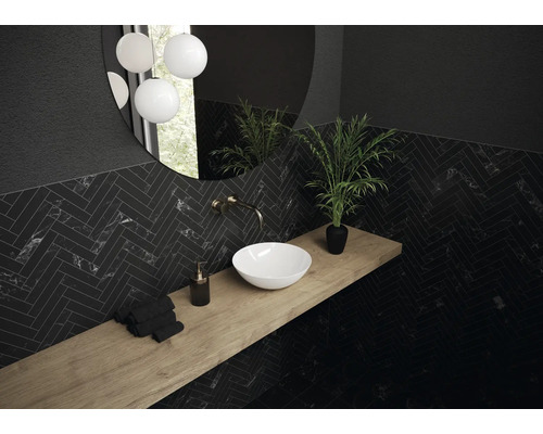 Salle de bains moderne avec lavabo, robinet, miroir et carreaux foncés à motifs