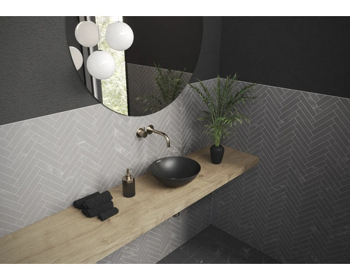 Salle de bains moderne avec lavabo, robinet, miroir et carreaux muraux à chevrons