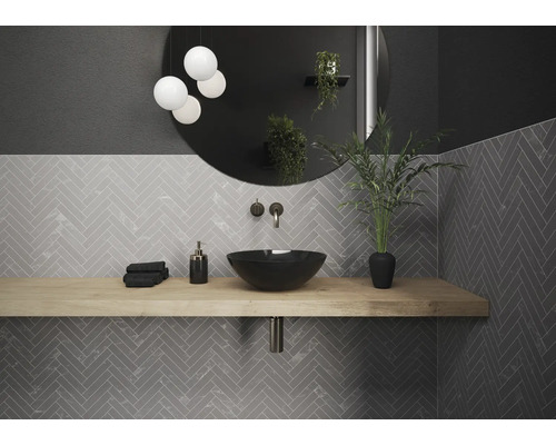 Badezimmer mit Waschtisch, Spiegel und grauen Fliesen im Fischgrätmuster