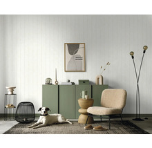 Salon avec commode verte, décorations, fauteuil et chien sur un tapis