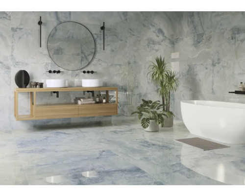 Salle de bains lumineuse avec lavabo, miroir, baignoire et carreaux bleus