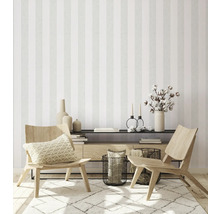 Wohnzimmer mit gestreifter Tapete, Holzstühlen und dekorativen Accessoires