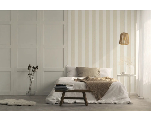 Schlafzimmer mit gestreifter Tapete, Bett und Holzhocker