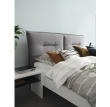 Lit avec tête de lit rembourrée, linge de lit et table de chevet