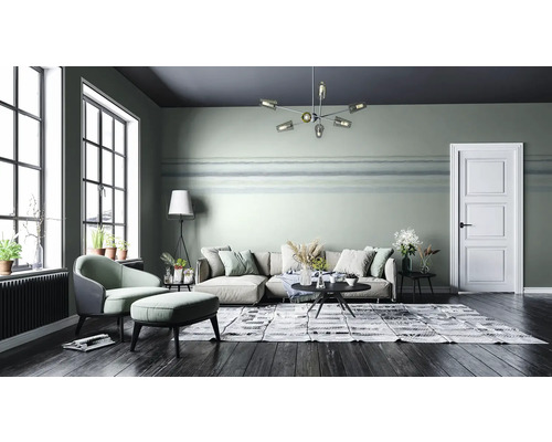 Wohnzimmer mit Sofa, Sessel, Teppich und Zimmerpflanzen für eine gemütliche Atmosphäre