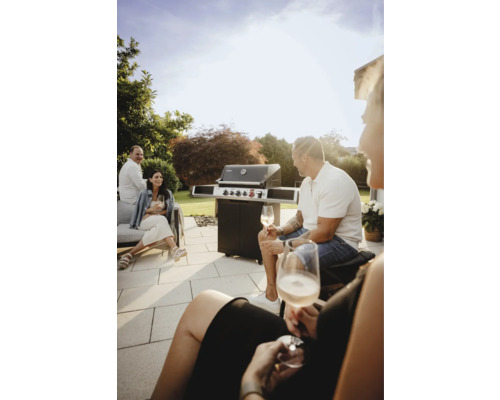 Des personnes sont assises sur la terrasse à côté d''un barbecue