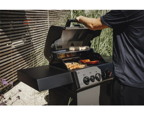 Gril à gaz avec des aliments grillés sous un couvercle ouvert