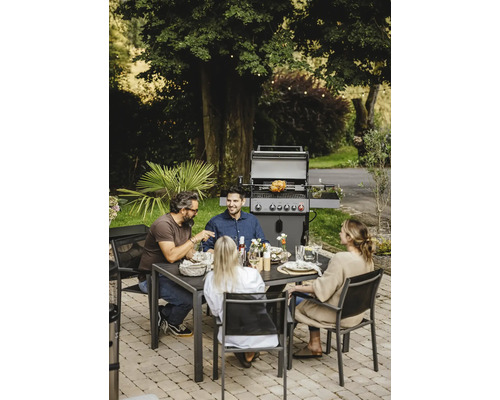 Scène de jardin avec barbecue, table à manger et quatre personnes