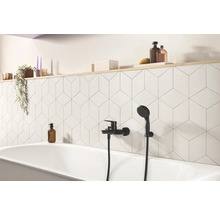 Badezimmer mit Badewanne, Armatur und geometrischen Fliesen