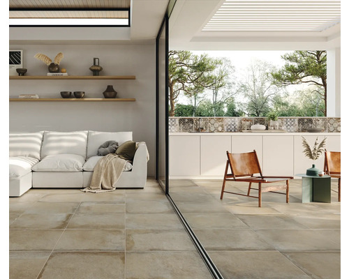 Espace de vie avec carrelage au sol, canapé et espace extérieur avec des sièges