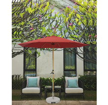 Scène avec un parasol de jardin rouge, deux chaises avec coussins et une petite table à l''extérieur.