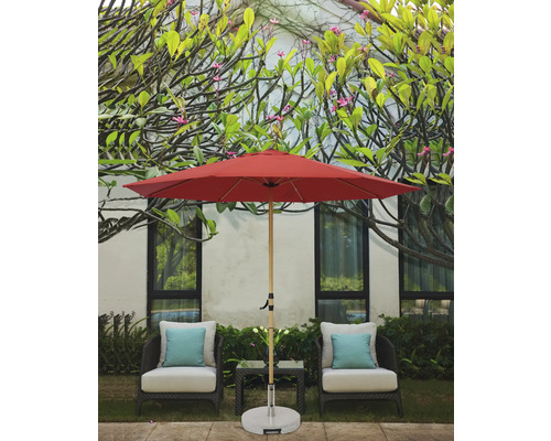 Scène avec un parasol de jardin rouge, deux chaises avec coussins et une petite table à l''extérieur.
