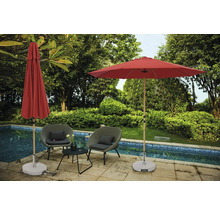 Scène avec deux fauteuils de jardin, une petite table, un parasol ouvert et un parasol fermé près d''une piscine