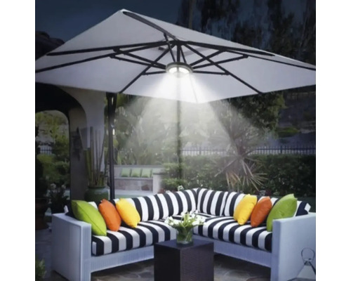 Szene mit einer Loungegruppe unter einem beleuchteten Sonnenschirm