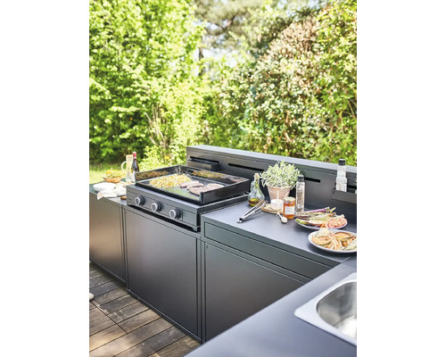 Cuisine de grill dans le jardin avec plaque de grill, grillades et divers ingrédients sur le plan de travail