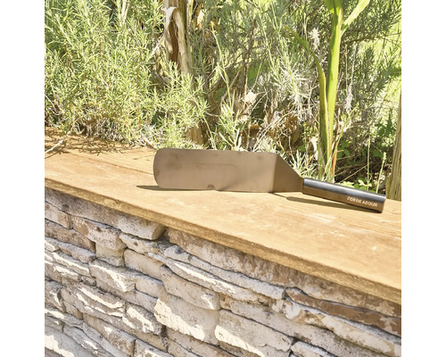 Grillwender aus Metall von Forge Adour auf einer Steinmauer