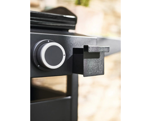 Vue détaillée d''un barbecue à gaz noir avec bouton rotatif et table d''appoint