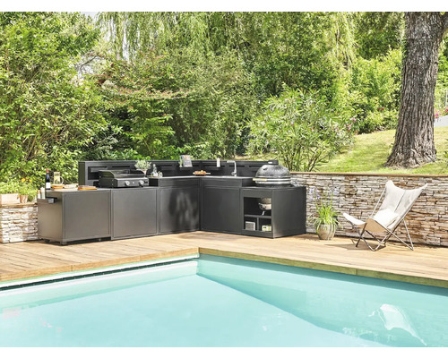 Cuisine extérieure sur une terrasse en bois à côté d''une piscine dans le jardin.